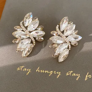 Close-up van elegante marquise-geslepen kristallen oorbellen met gouden strass accenten