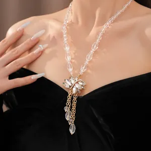 Detail van de elegante kristallen kralenketting met een hanger van strasbloemen en kwastje