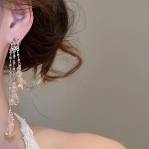 Detaillierte Nahaufnahme eleganter mehrlagiger rosa Kristall-Ohrringe am Model