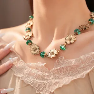 Detailansicht einer Vintage-Goldblumenhalskette mit eleganten grünen Harzperlen
