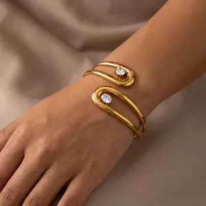 Detailopname van een gouden roestvrijstalen geometrische armband met zirkonia.