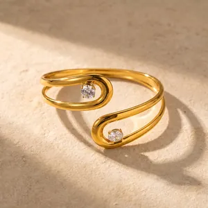 Gedetailleerde close-up van een gouden geometrische roestvrijstalen armband met zirkoon.