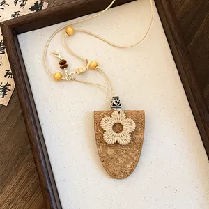 Detailopname van een Boheemse bloemenketting met kurken hanger en rotan details op display