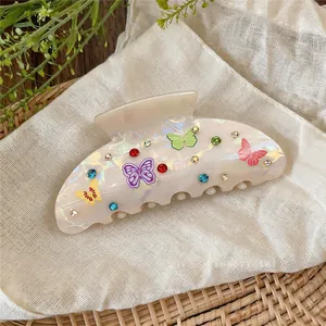 Detail view of acrylic hair claw clip with colorful butterflies and rhinestones