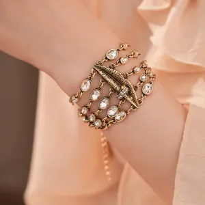 Detailaufnahme eines vintage mehrlagigen Armbands mit ovalen Kristallsteinen am Handgelenk