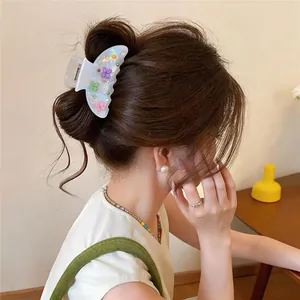 Asian model wearing a stylish iridescent acrylic hair claw clip with colorful butterfly patterns