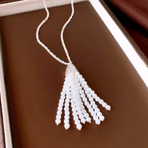 Detailansicht einer silbernen Halskette mit einem eleganten weißen Perlenquasten-Anhänger