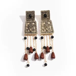 Boucles d'oreilles vintage en métal doré avec perles en acrylique marron et noir sur blanc