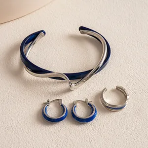 Detailansicht eines blau-silbernen geometrischen Schmucksets mit Armreif und Ohrringen