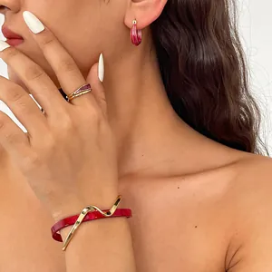 Elegantes rotes Acetat-Schmuckset mit unregelmäßiger geometrischer Goldverzierung.