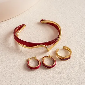 Detailansicht eines Vintage-Schmucksets aus burgunderfarbenem Acetat und Gold mit Ring und Ohrringen