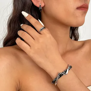 Modell trägt unregelmäßiges geometrisches Schmuckset aus schwarzem Acetat und Silber