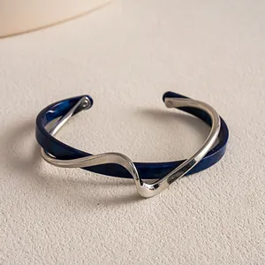 Nahaufnahme eines Vintage-Armreifs aus Acetat und silberfarbenem Metall in Wellenform