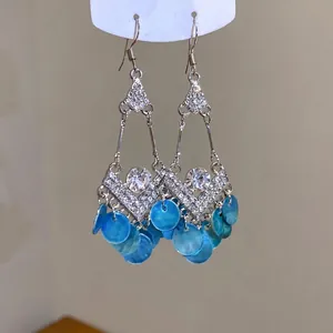 Pendientes de gancho estilo étnico vintage con pedrería y colgantes de concha azul.
