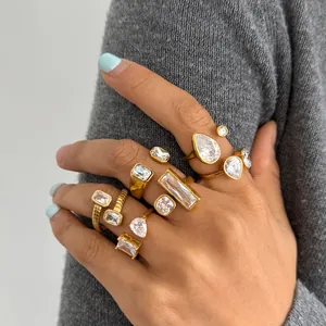 Detailed view of several gold plated stainless steel geometric rings with clear zircons