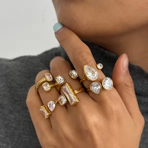 Detail view of gold-plated stainless steel rings with various zircon shapes on a hand.