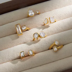 Detailed close-up showing assorted geometric zirconia rings in a plush beige jewelry tray