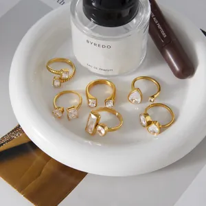 Detail shot of various 18k gold plated titanium steel rings featuring geometric zircons