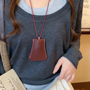 Detailweergave van een bruine leren geometrische sleuteletui ketting op een model