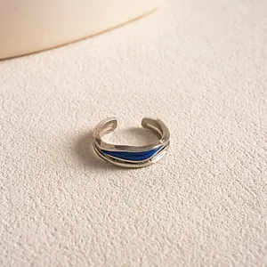 Detailansicht eines unregelmäßigen silberfarbenen Rings mit blauem Emaille-Inlay.