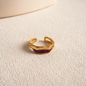Detailansicht eines goldenen verstellbaren Rings mit einer roten Emaille-Einlage