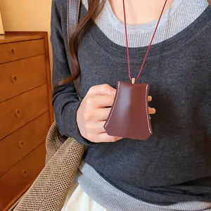 Detailweergave van een minimalistische bruine leren geometrische sleutelzak ketting.