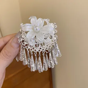 Detailed view of a vintage Chinese style hair clip with white pearl flower and silver tassels