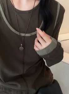 Detailansicht einer minimalistischen Herzkette mit dunkler Lederkordel an einem Modell.