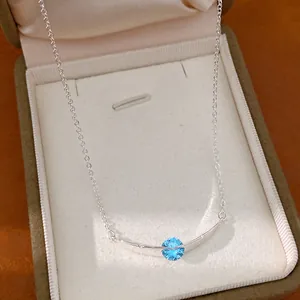 Elegante zilverkleurige ketting met gebogen staaf en fonkelende blauwe zirkoon in geschenkdoos
