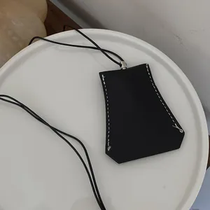 Nahaufnahme einer schwarzen geometrischen Leder-Schlüsseltasche mit weißen Nähten