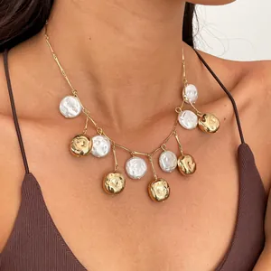 Detailed view of vintage metallic wrinkled gold discs and pearl fringe necklace on model