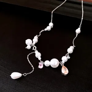 Vista dettagliata di un'elegante collana di perle con ciondoli a goccia di strass
