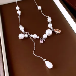 Dettaglio di un'elegante collana di perle con gemme a goccia e nappa in argento