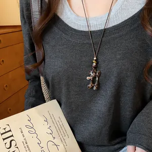Vue détaillée d'un pendentif ours léopard sur un collier pull en cordon de cuir