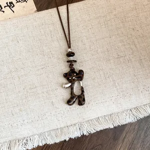 Vue détaillée d'un pendentif ours à motif léopard marron sur un collier en cuir