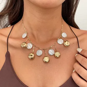 Detailed view of vintage metallic necklace with wrinkled pearl tassels worn by model.