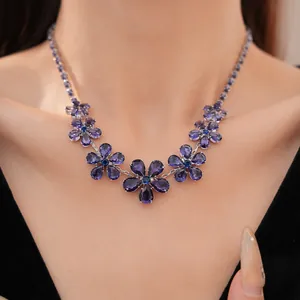 Close-up van elegante paarse zirkoon bloemenketting om de nek van een model, luxe look