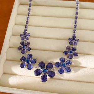 Gedetailleerde opname van elegante paarse zirkoon bloemenketting in een sieradenbakje
