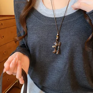 Vue détaillée du collier pendentif ours léopard porté sur un pull en tricot gris