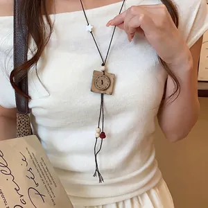 Long collier de style chinois moderne avec un pendentif en forme de bouton en bois