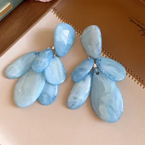 Vue détaillée de boucles d'oreilles en résine marbrée bleu clair en forme de goutte
