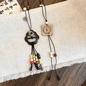 Detail of retro Chinese style flower and button pendant necklaces on rustic linen