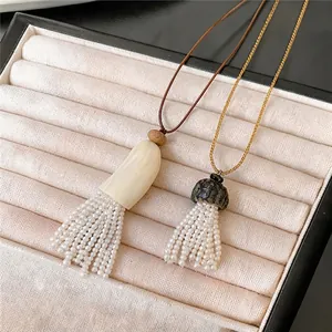Elegante boheemse parelmoer kwastjes ketting met lederen koord en hoornen hanger