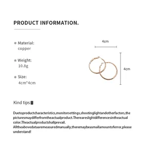 Vue détaillée des créoles en cuivre rose montrant la taille 4 cm et la texture plissée