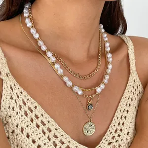 Detailed view of a four-piece layered necklace set featuring pearls and gold chains