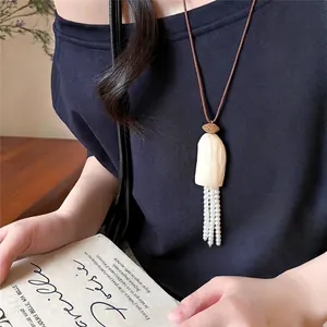 Detailaufnahme einer minimalistischen Lederkordel-Halskette mit feinen Perlenquasten