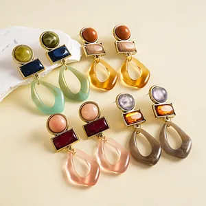 Dettaglio di orecchini geometrici vintage con resina marmorizzata e oro