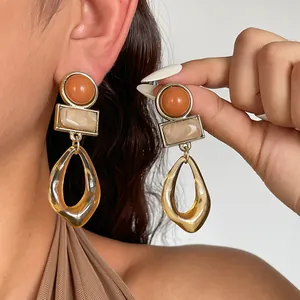 Dettaglio degli orecchini vintage in acrilico geometrico con trama in ambra e marmo