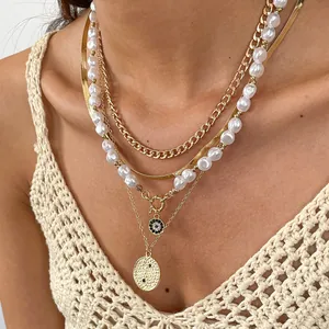 Close-up detail of four-layer layered necklace featuring gold chains and pearl strands