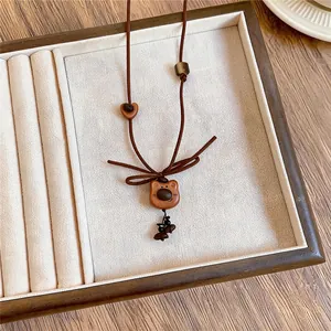 Vista detallada del collar con colgante de oso de madera vintage con lazo de cuerda